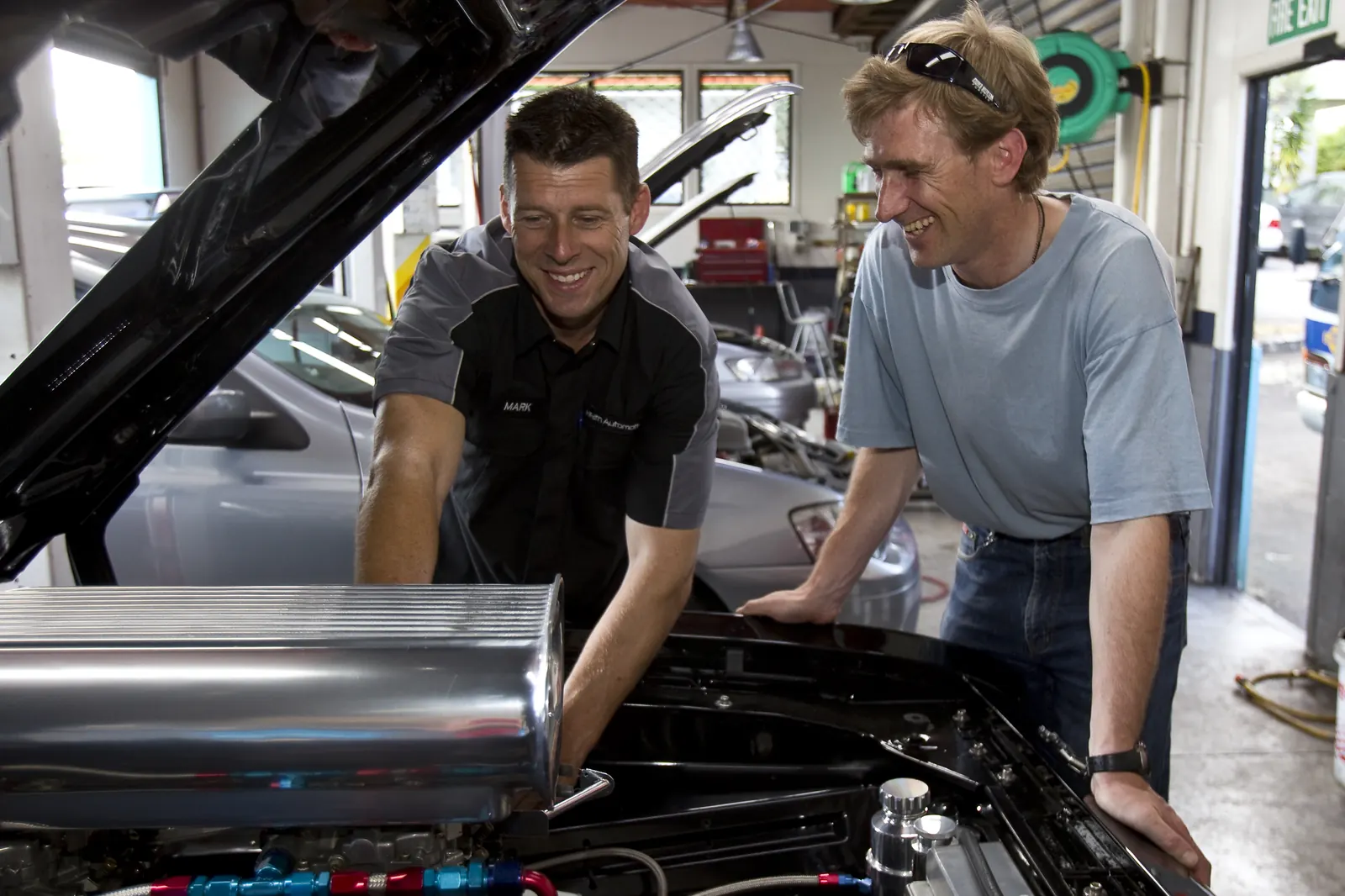 Mark and a customer discussing an open engine bay