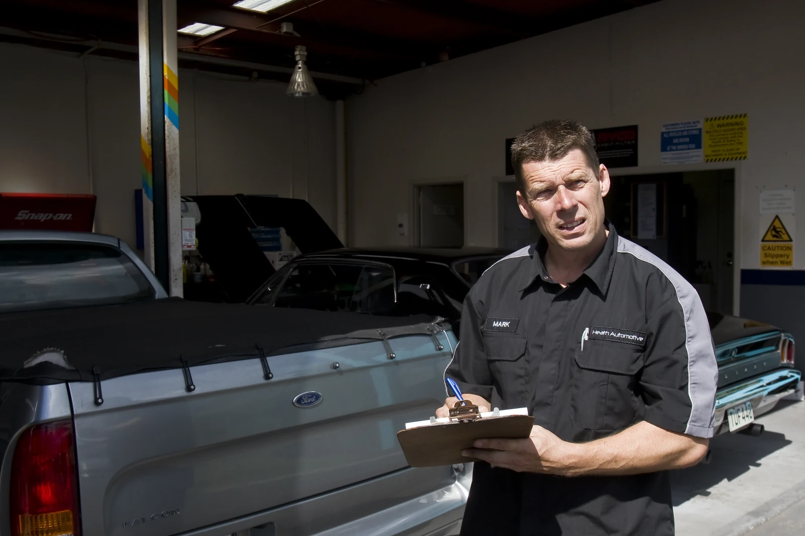 Mark with clipboard in the workshop bay